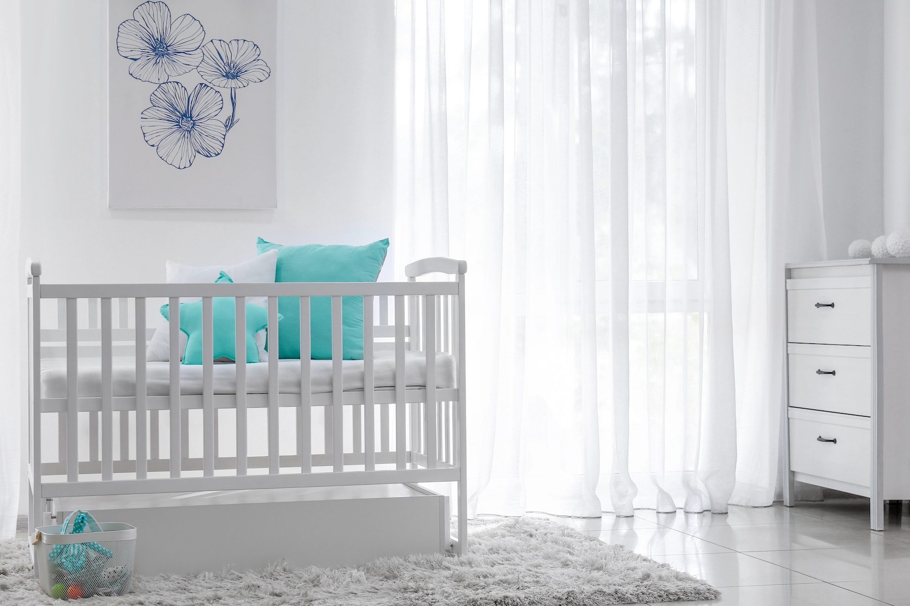 Bright and meticulously clean baby nursery with white crib and calming aqua accents, an example of a child-safe and healthy home environment.