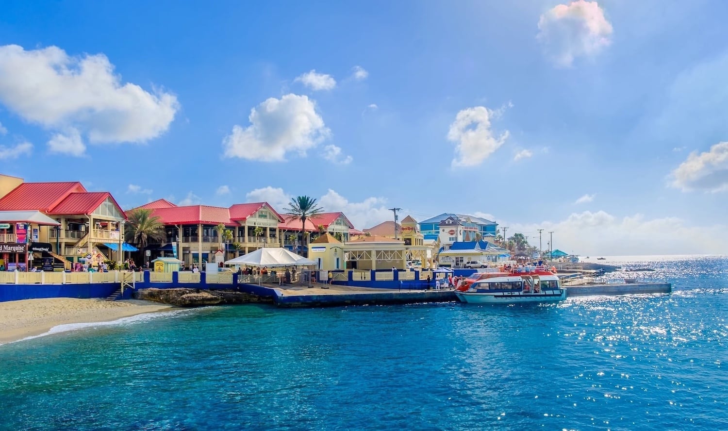 Colorful George Town waterfront buildings and harbor with tourist boats in Grand Cayman